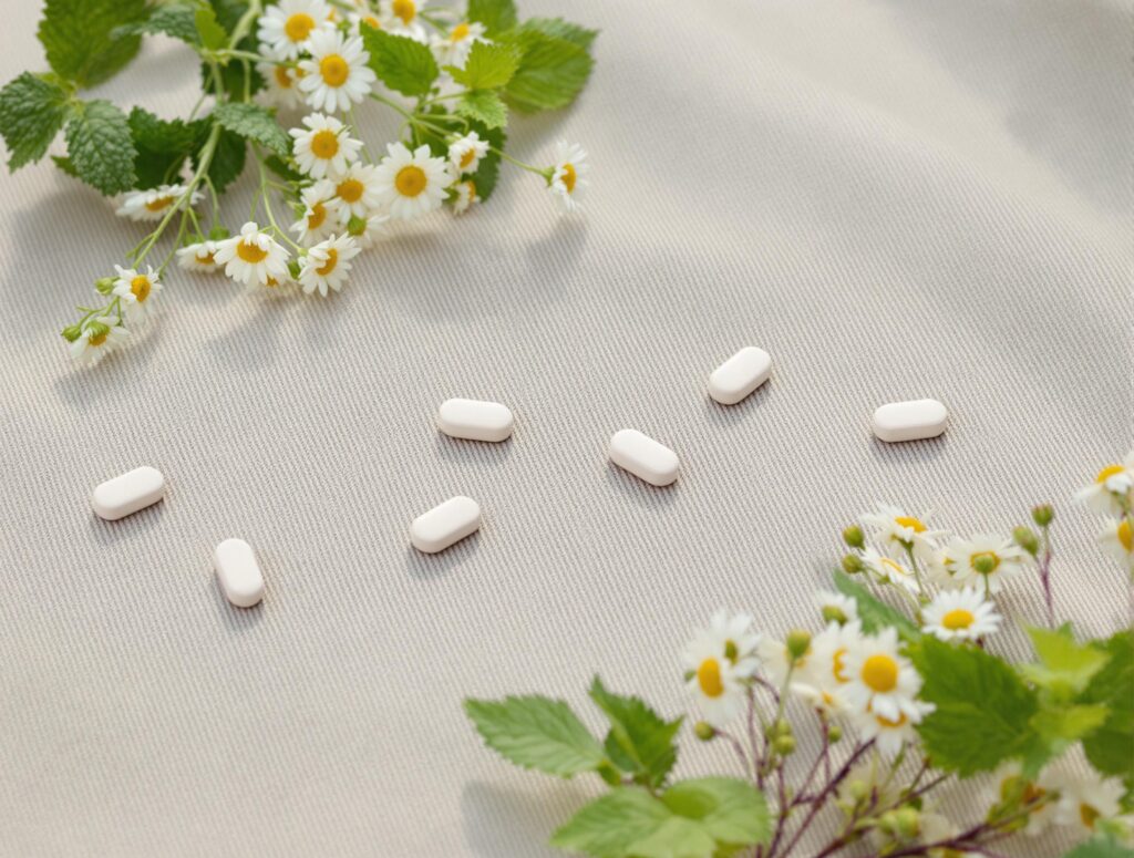 Herbal supplement tablets on rustic fabric with mint and chamomile, embodying an earthy, organic aesthetic.
